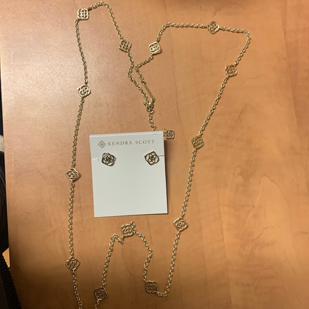 Kendra Scott gold signature stud earrings and long matching necklace .
